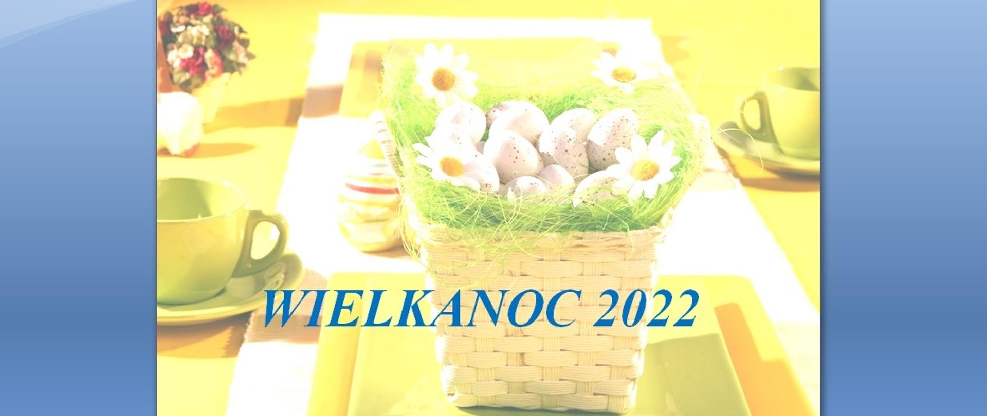 Kolorowa kartka świąteczna w żółtych kolorach, z koszykiem i jajkami w tle oraz niebieskim napisem Wielkanoc 2022.