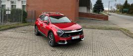 Fotografia przedstawia samochód operacyjny Kia Sportage na parkingu przed budynkiem Komendy Powiatowej PSP w Strzelcach Krajeńskich