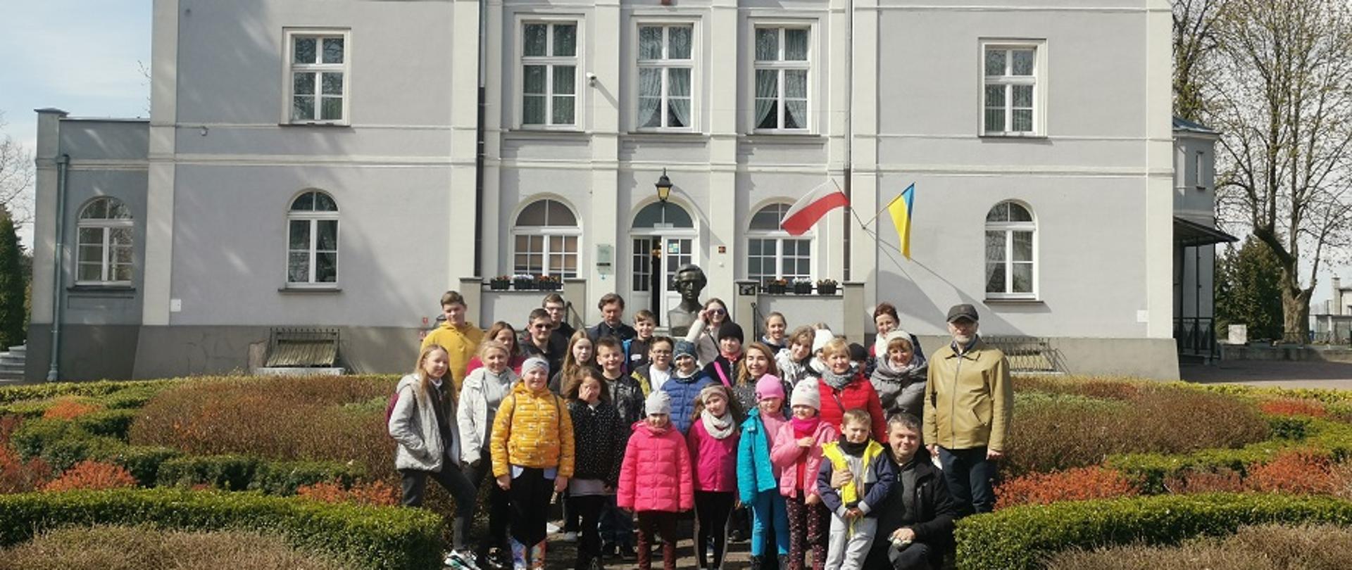 Uczniowie szkoły z opiekunami na tle budynku muzeum Fryderyka Chopina w Szafarni
