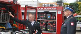 Na zdjęciu strażak OSP prezentuje sprzęt na samochodzie pożarniczym zastępcy śląskiego komendanta wojewódzkiego