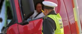 Funkcjonariusz lubuskiej Inspekcji Transportu Drogowego kontroluje trzeźwość kierowcy ciężarówki na autostradzie A2.