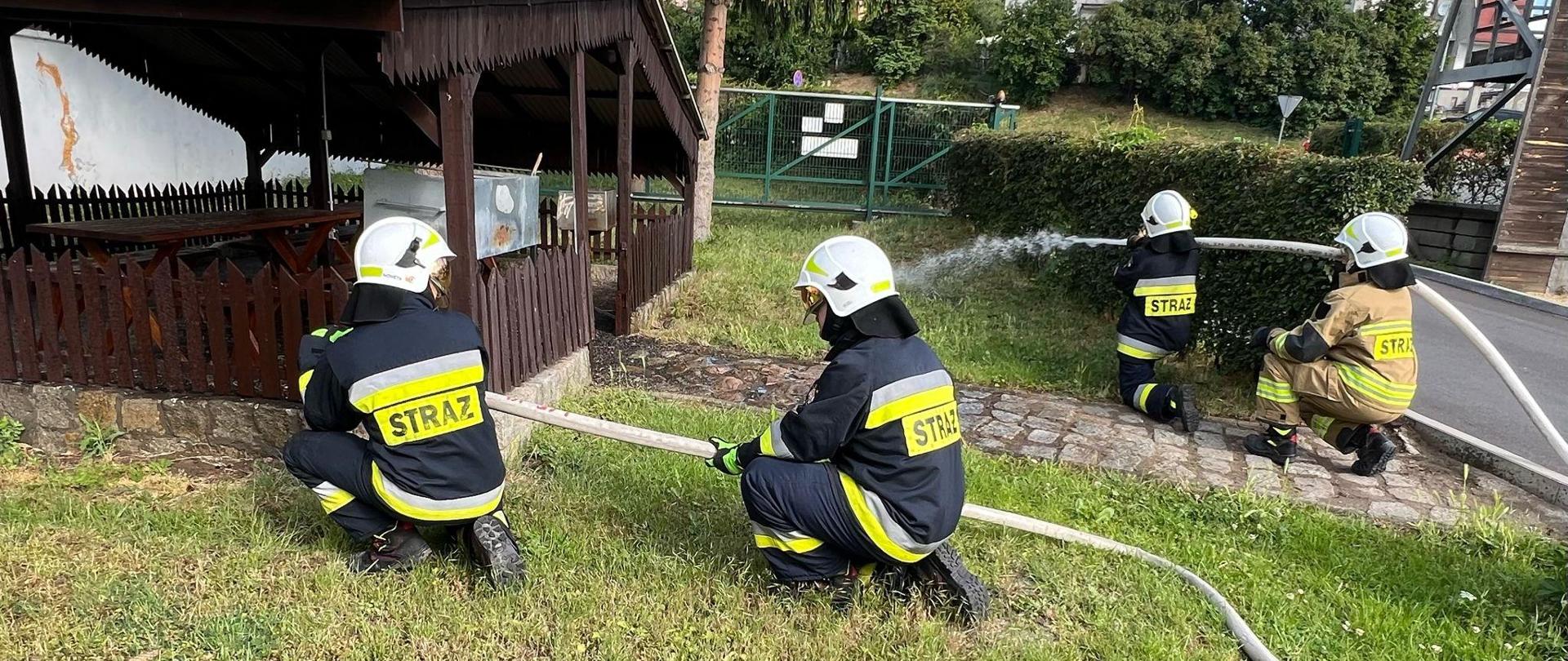strażacy lejący wodę z węży