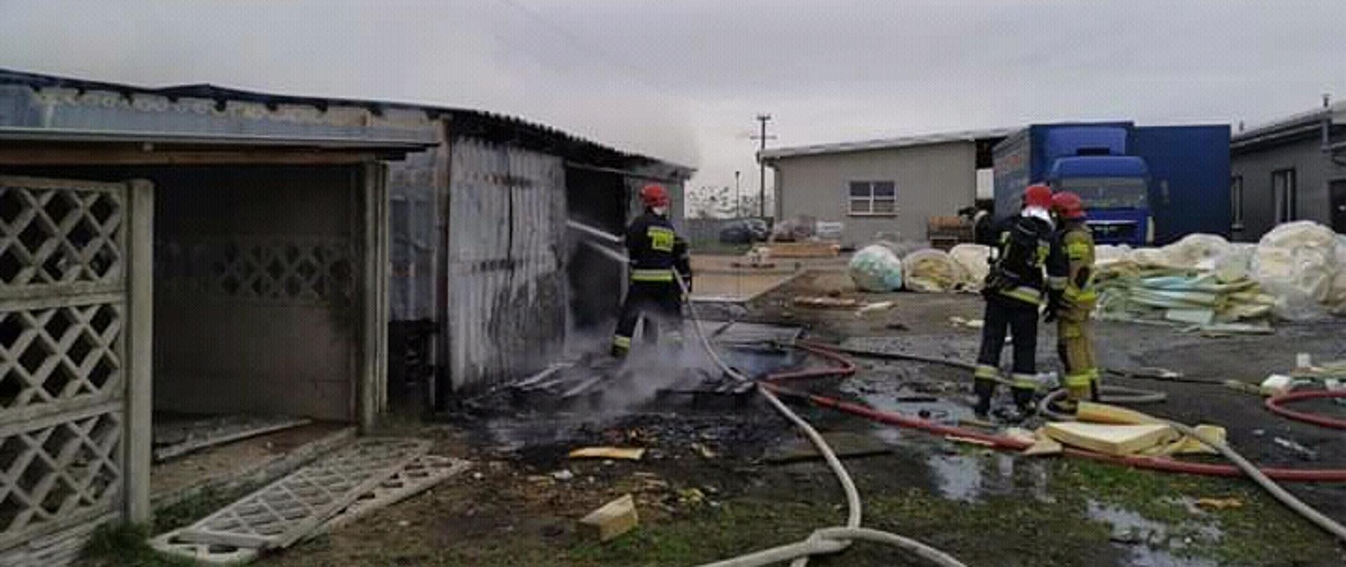 Strażacy gaszący pożar magazynu.