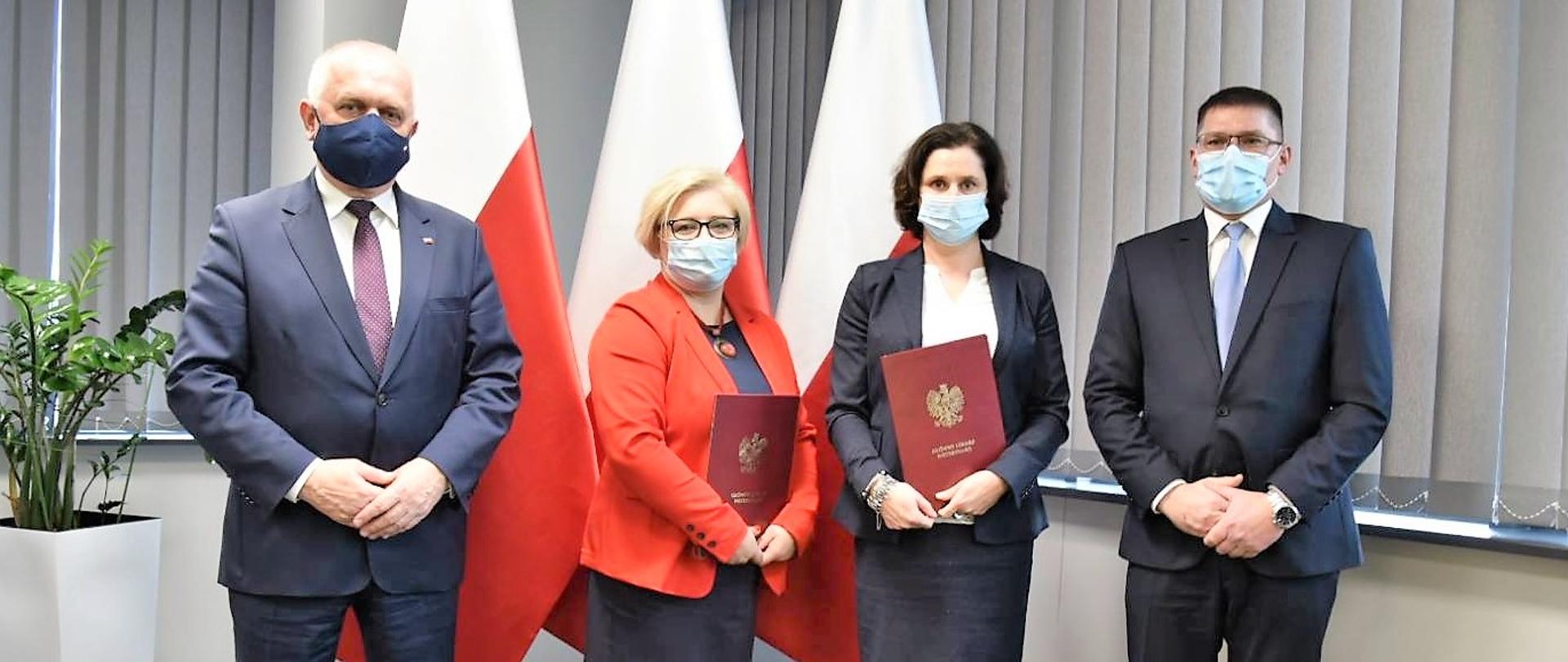 Od lewej na tle flag stoi wojewoda, wojewódzki lekarz weterynarii, jego zastępczyni i główny lekarz weterynarii 