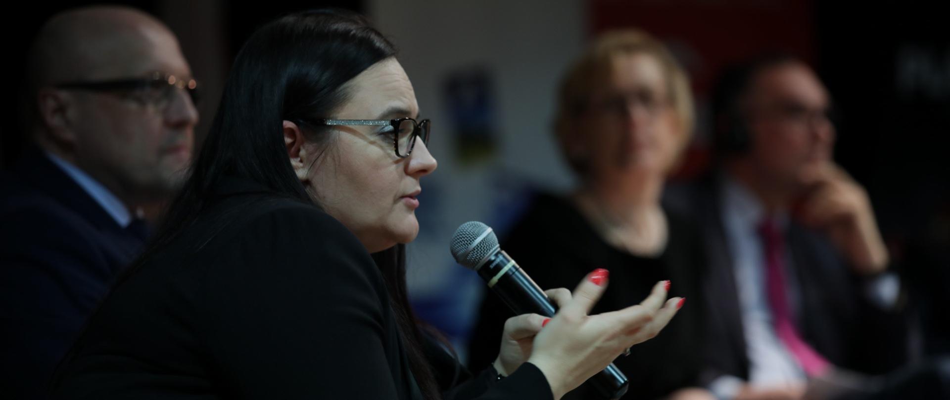 Zdjęcie minister Jarosińskiej-Jedynak, która siedzi i mówi do mikrofonu 