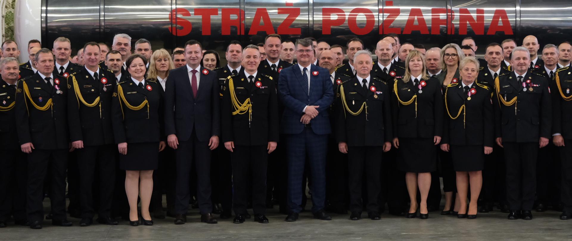 Funkcjonariusze pozujący do wspólnego zdjęcia z Ministrem i komendantem głównym