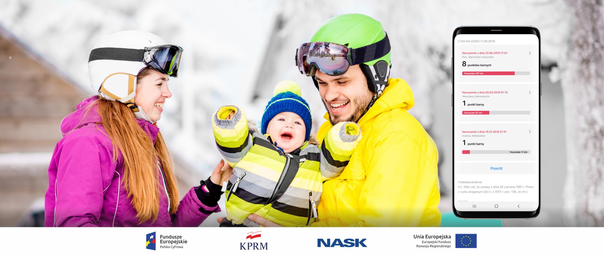 Na zdjęciu widać uśmiechniętą młodą parę, mężczyzna trzyma na rękach małe dziecko. Rodzice mają na sobie kaski narciarskie, ubrani są w zimowe kurtki, w tle ośnieżony krajobraz i fragment drewnianego, górskiego domu. 