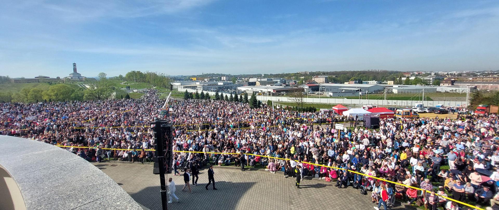 Liczne zgromadzeni na błoniach przed Sanktuarium ludzie - uczestnicy zgromadzenia religijnego. 