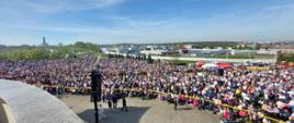 Uczestnicy uroczystości religijnych w krakowskich Łagiewnikach. Duża grupa ludzi zgromadzona na błoniach przed Sanktuarium.