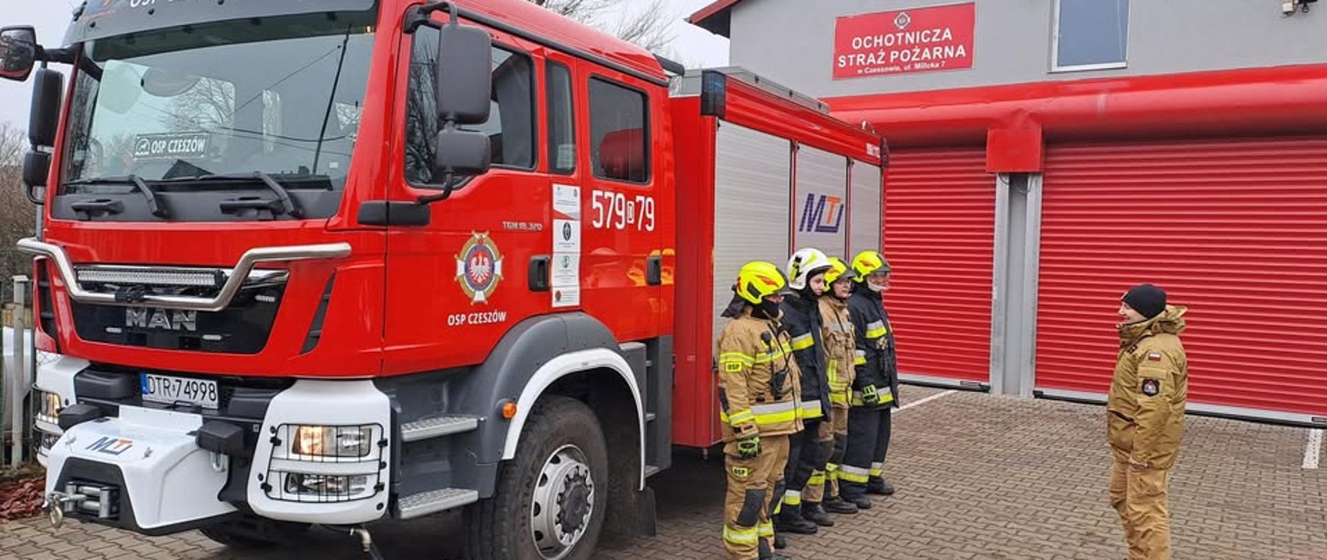 Strażacy przy wozie bojowym