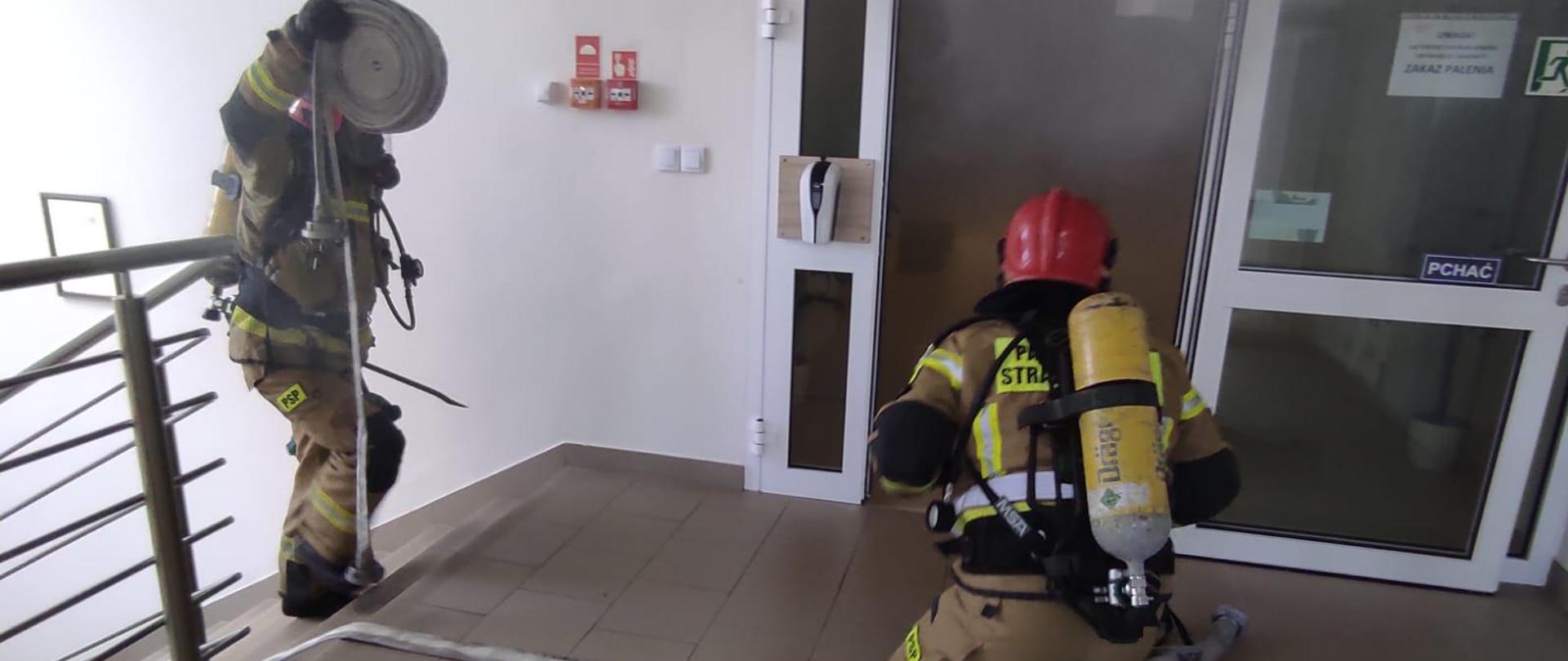 Strażacy przygotowują się do wejścia w strefę zadymioną