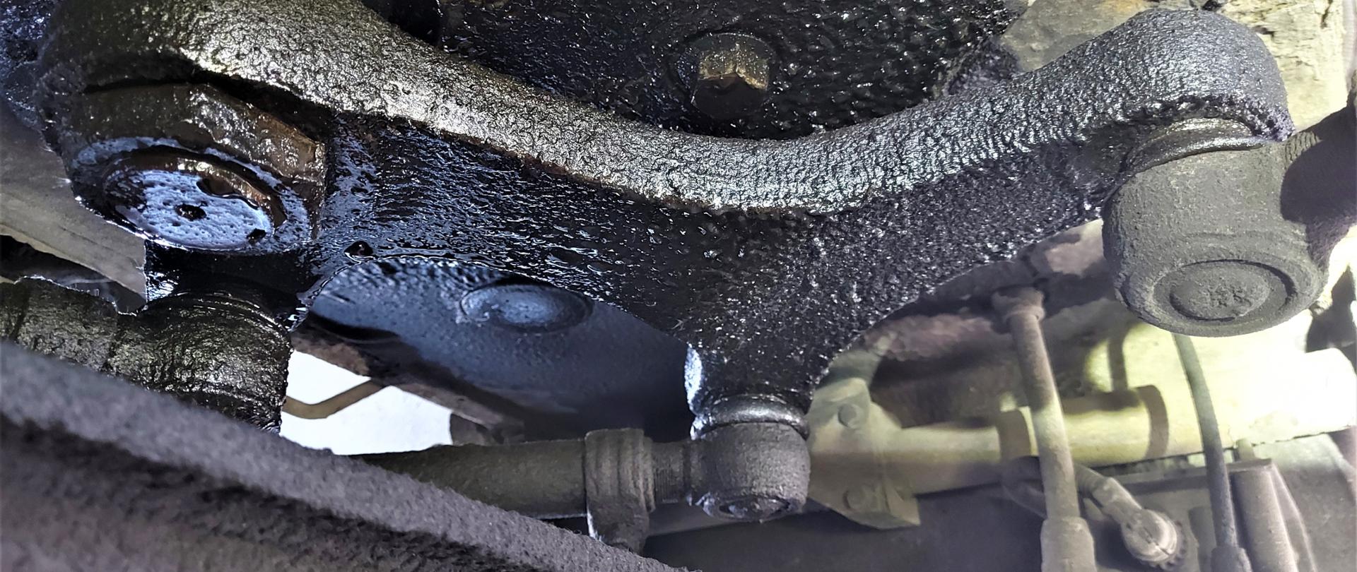 Miejsce wycieku płynu eksploatacyjnego z siłowników układu wspomagania kierowniczego kontrolowanego autokaru.