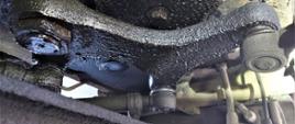 Miejsce wycieku płynu eksploatacyjnego z siłowników układu wspomagania kierowniczego kontrolowanego autokaru.