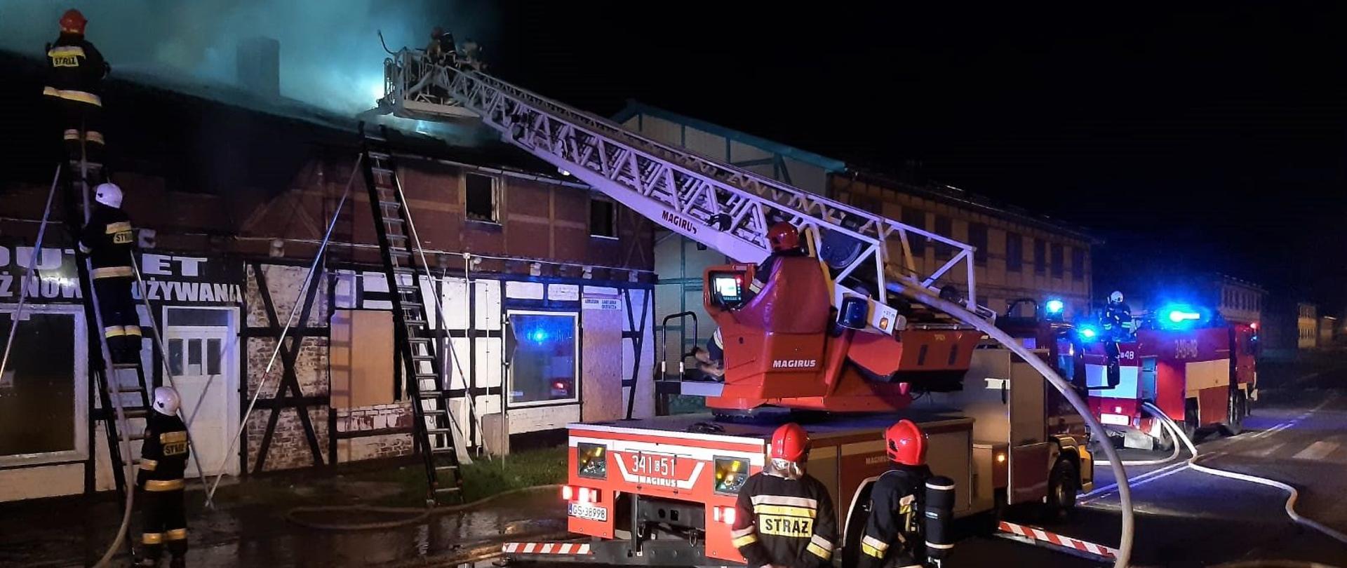 Pożar pustostanu w Kępicach. Na zdjęciu sprawiona drabina mechaniczna wraz ze strażakami w koszu, gaszącymi palący się pustostan. 