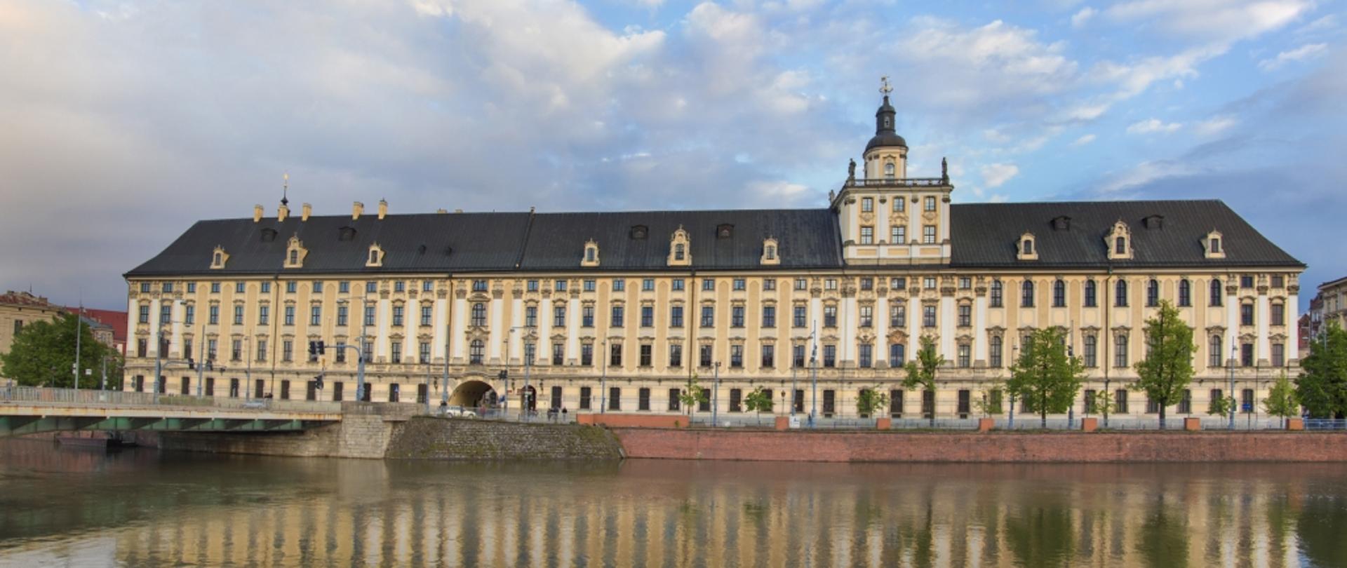 Budynek Uniwersytetu - stary gmach z wieżyczką stoi nad wodą
