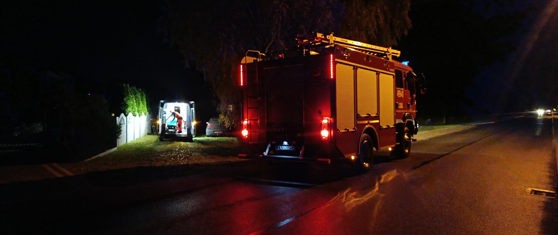 Zdjęcie przedstawia wozy służb ratowniczych stojące przy miejscu prowadzonych działań. 