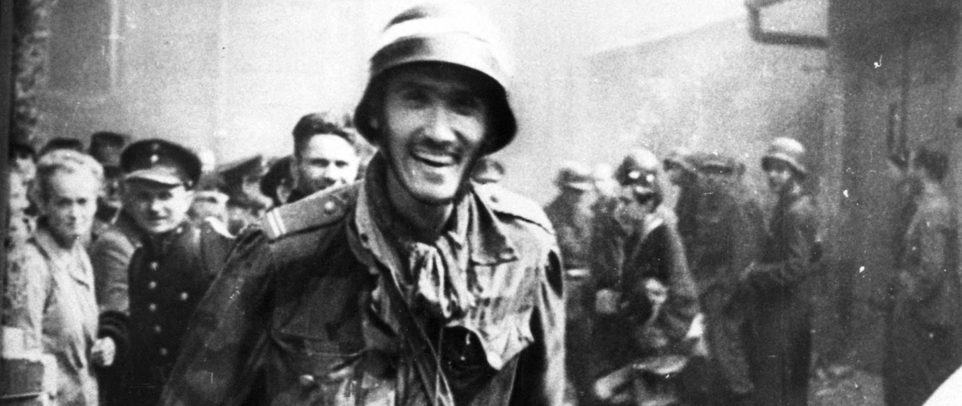 Zdjęcie czarno białe. Przedstawia grupę ludzi 