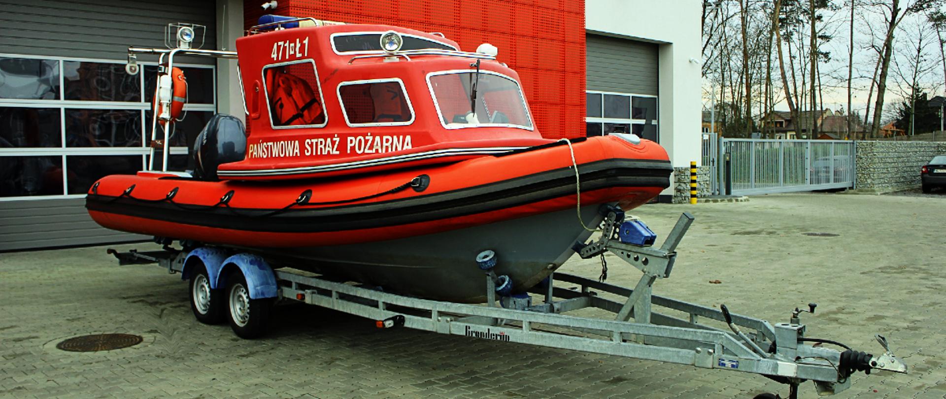 Łódz hybrydowa Arimar X690 SCUBA - JRG Legionowo. PRzed budynkiem komendy na przyczepie do przewozu łódz z szarym dnem i czerwonymi balonami. Kabina czerwona na boku napis PSP oraz 471 - Ł1. 