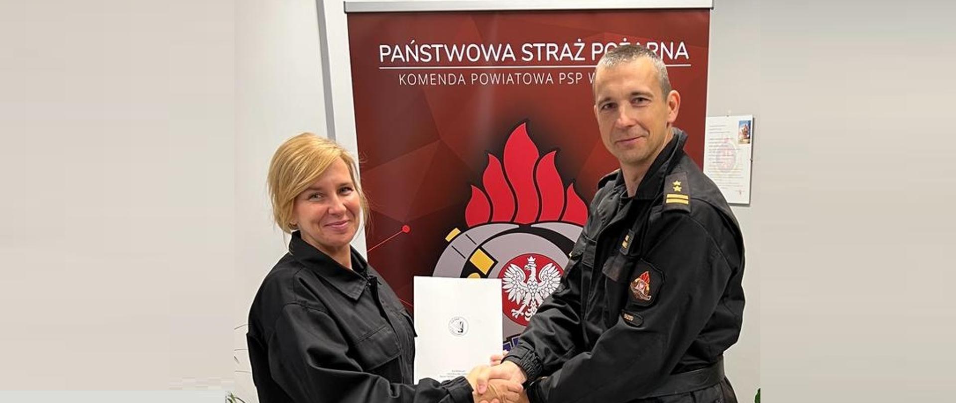 Komendant KP PSP w Brzegu wraz ze strażakiem, który zakończył szkolenie podstawowe w zawodzie strażak.