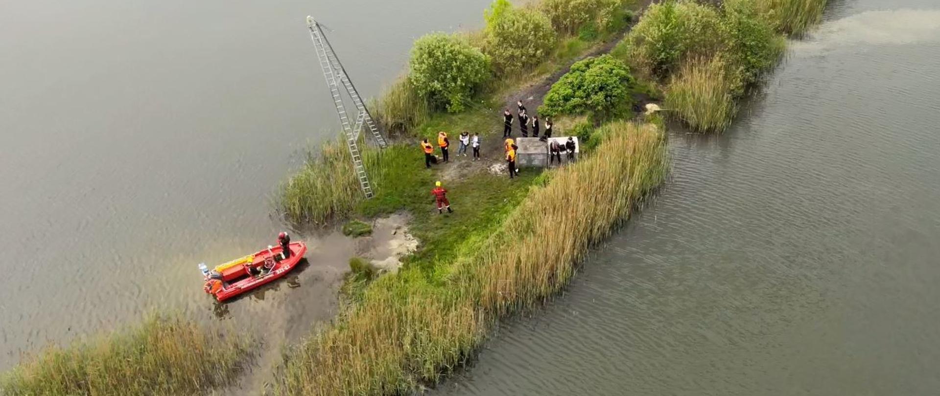 Strażacy podejmują osoby uwięzione na wyspie wymagające ewakuacji na brzeg