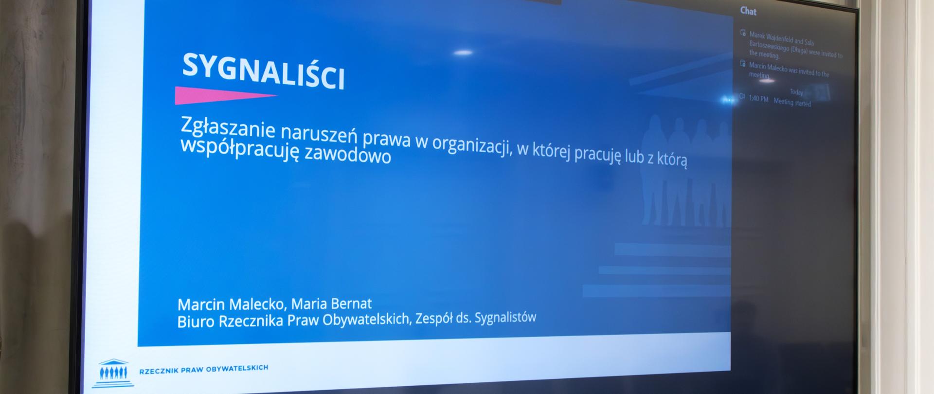 Ekran projektora z napisem "Sygnaliści. Zgłaszanie naruszeń prawa w organizacji, w której pracuję lub z którą współpracuję zawodowo"