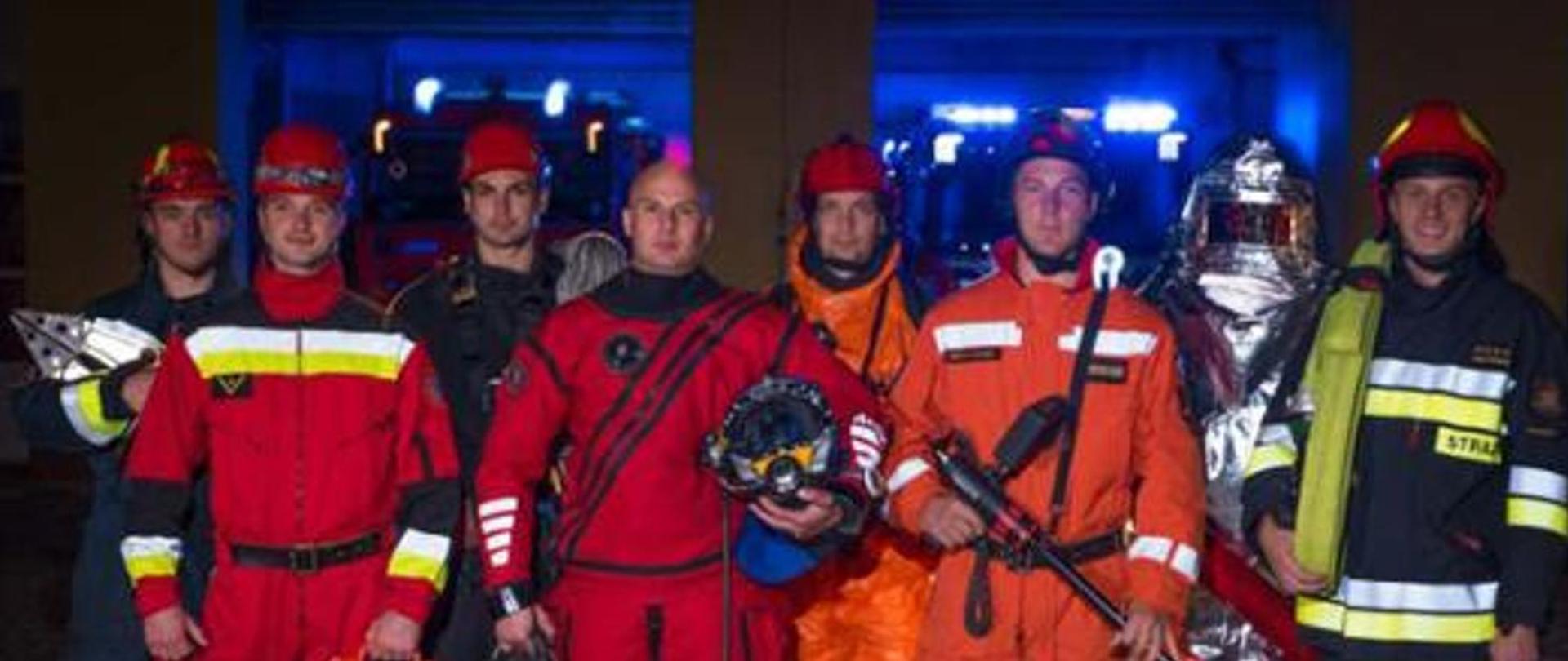 grupa strażaków w różnych umundurowaniach