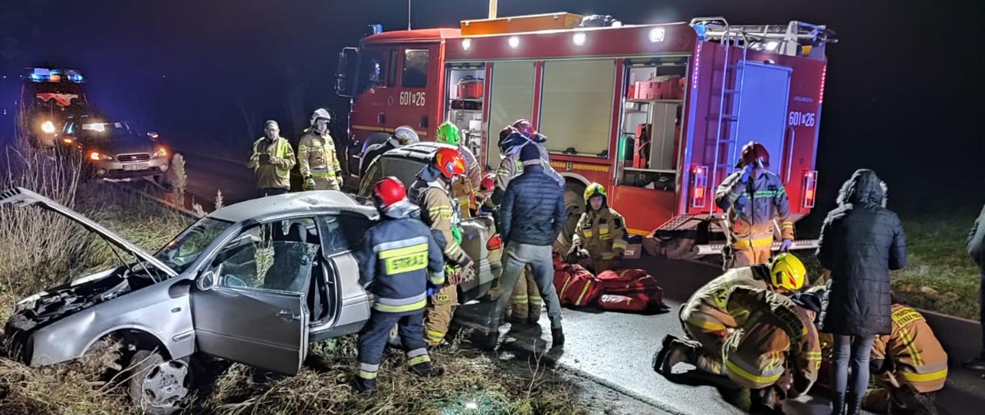 Strażacy udzielający kwalifikowanej pomocy przedmedycznej poszkodowanemu.