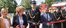 Strażacy i osoby cywilne przecinają wstęgę