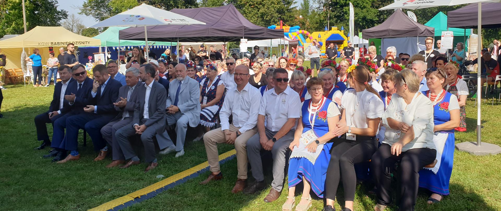 grupa siedzących na krzesłach osób