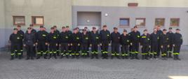 Egzamin kończący Szkolenie Podstawowe Strażaków Ratowników Ochotniczych Straży Pożarnych 04.09.2022 r. - Przed budynkiem Komendy Powiatowej Państwowej Straży Pożarnej w Sokołowie Podlaskim na zbiórce strażacy stoją na zbiórce w szeregu w mundurach koszarowych