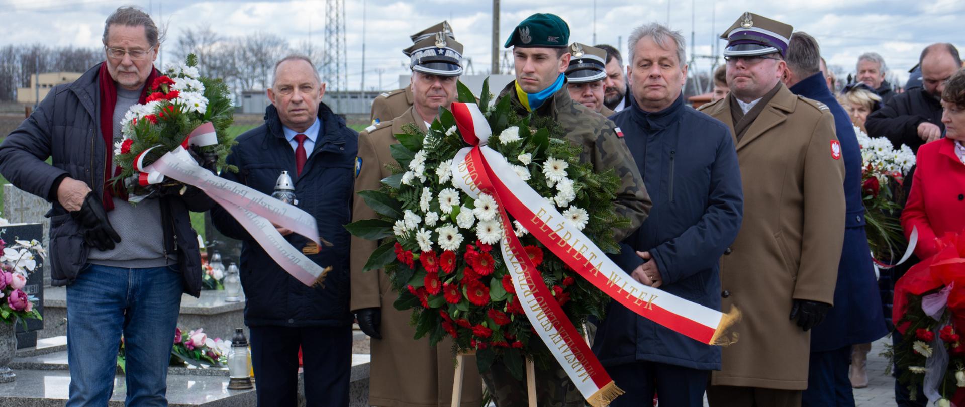 Na zdjęciu uczestnicy uroczystości. Na pierwszym planie żołnierz, trzymający duży wieniec z szarfą Marszałek Sejmu RP.