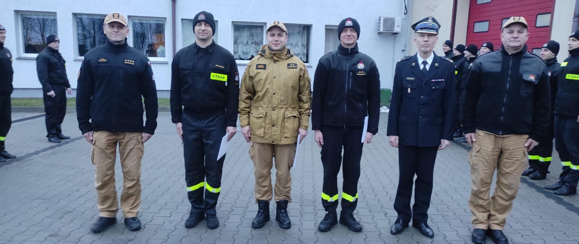 Zdjęcie przedstawia moment wręczania awansów na wyższe stanowiska służbowe na placu JRG