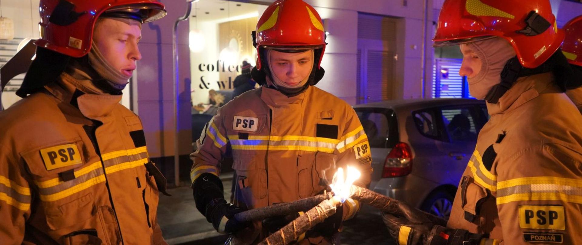 3 strażaków zapalających pochodnie