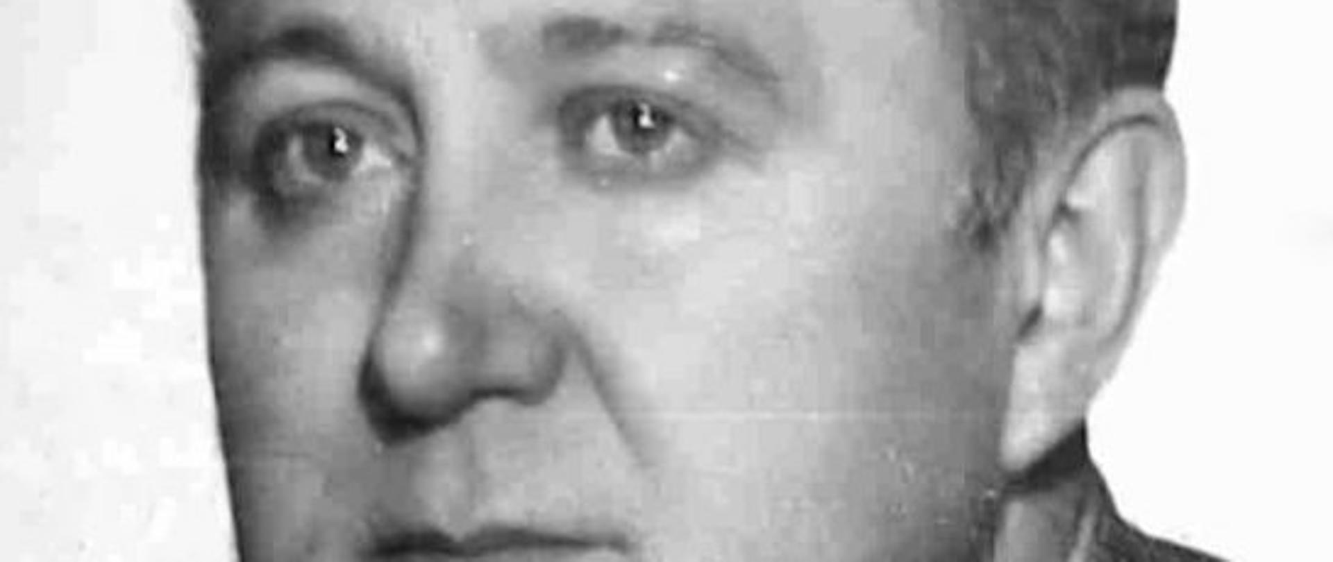 zdjęcie czarno białe przedstawia mężczyznę w garniturze w białej koszuli i z krawatem, 