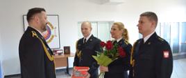 Strażacy wręczają kwiaty i pamiątkowe gadżety strażakowi "emerytowi"