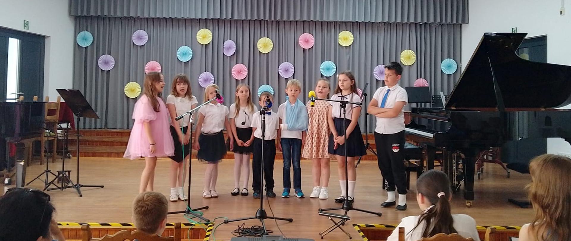 Uczniowie śpiewają na scenie podczas koncertu