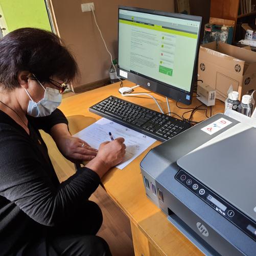 kobieta wypełnia dokumenty związane z przekazaniem komputera dla biblioteki