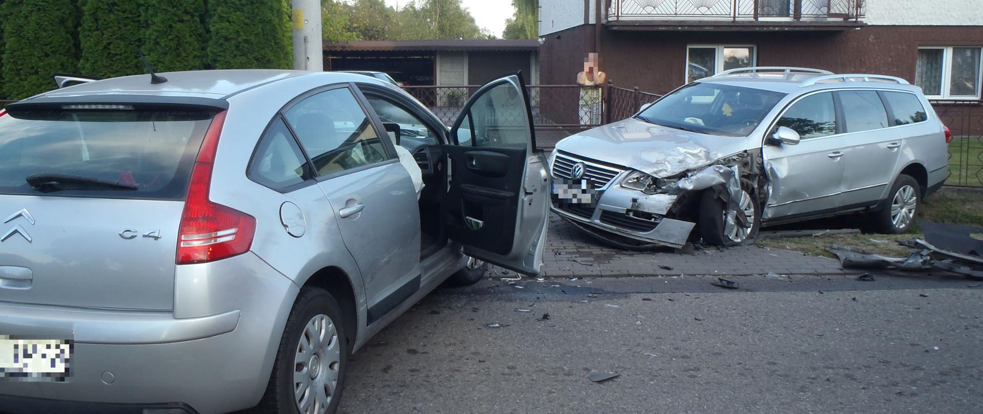 Dwa samochody osobowe po zderzeniu czołowym. Jeden stoi na drodze drugi na poboczu. 