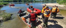 strażacy wchodzący na łodzie przed wypłynięciem na Wisłę