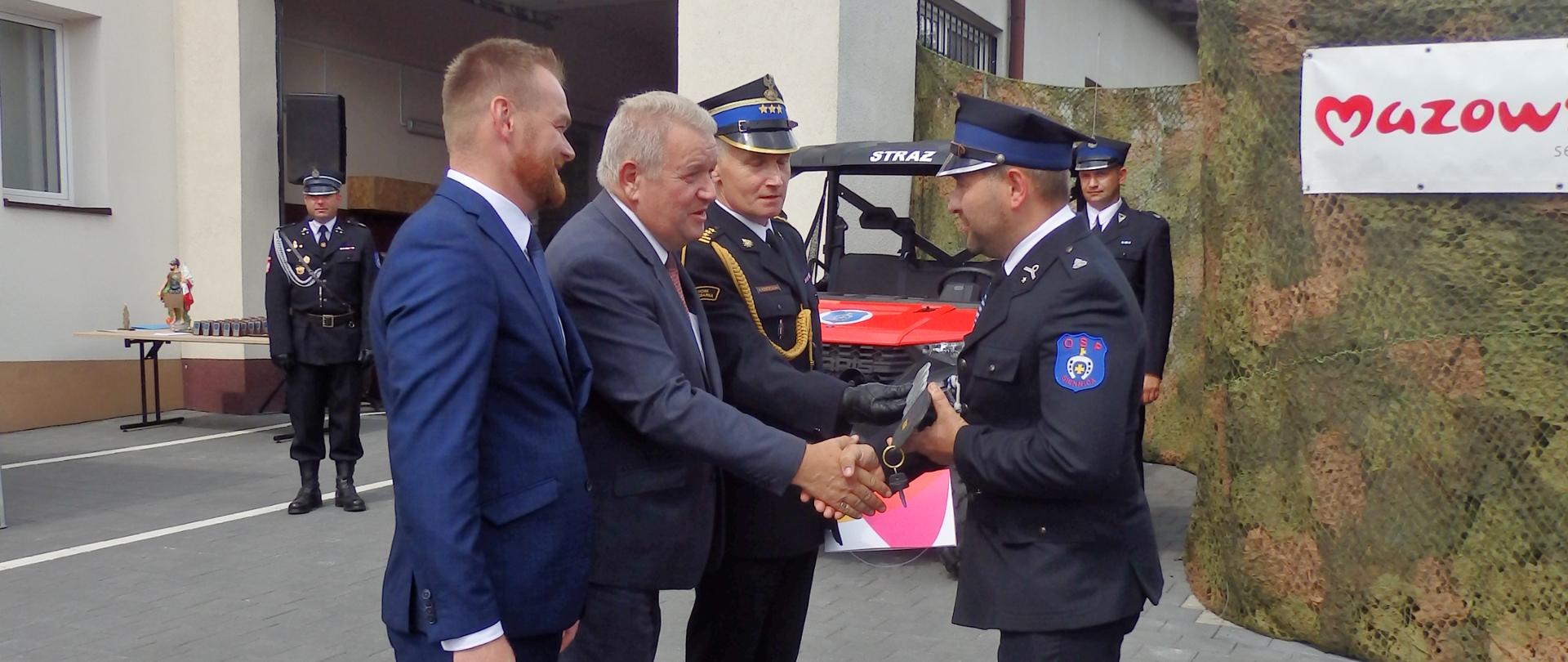 I Wicewojewoda ściska dłoń strażaka OSP i gratuluje po przekazaniu kluczy od pojazdu UTV 