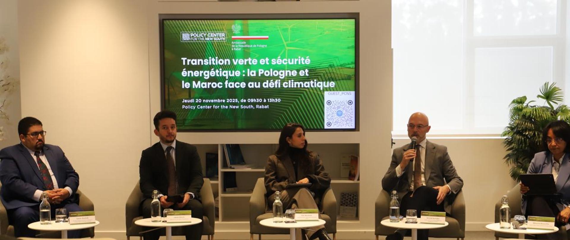 Personnes assises dans des fauteuils devant des tables basses, une personne tient le micro