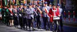 Zdjęcie przedstawia przemarsz pocztów sztandarowych przez miasto.