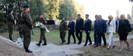 Delegacja składa kwiaty pod pomnikiem.