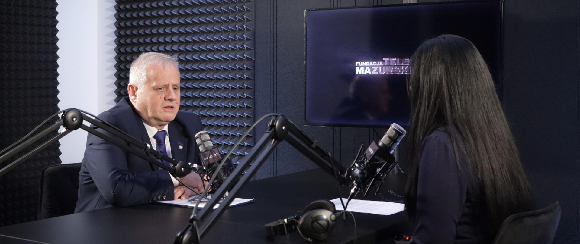 Mężczyzna udziela wywiadu Kobiecie w studiu telewizyjnym 