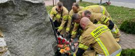 STRAŻACY SKŁADAJĄ ZNICZE POD POMNIKIEM