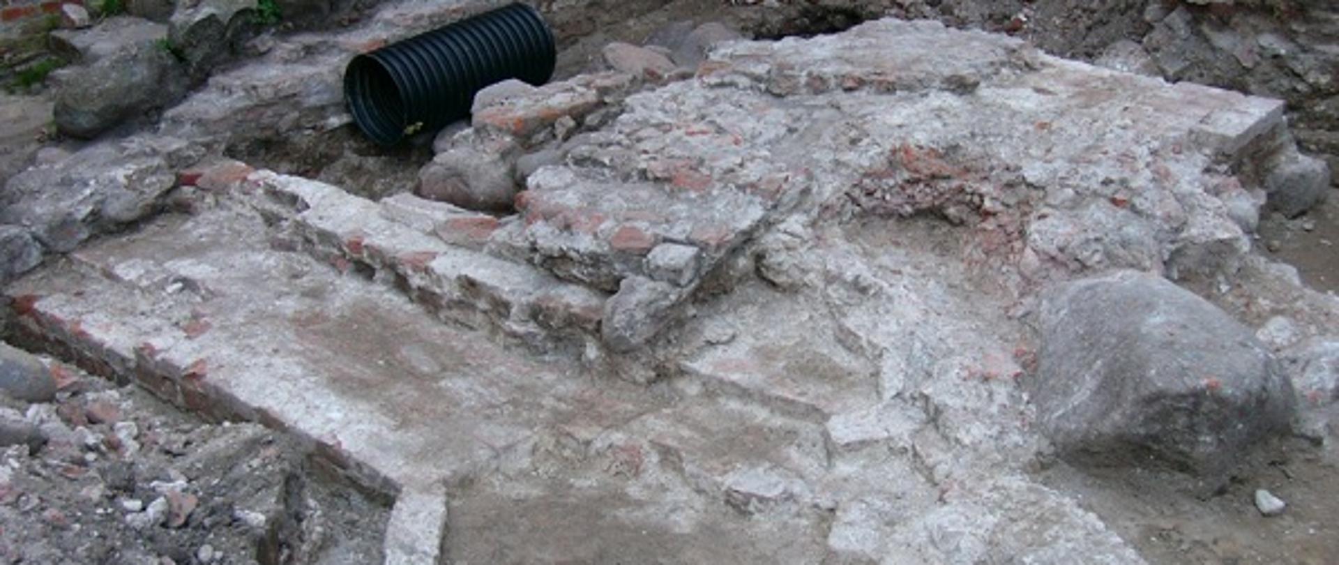 odkryte w ziemi, częściowo zniszczone fragmenty muru - fundamentów