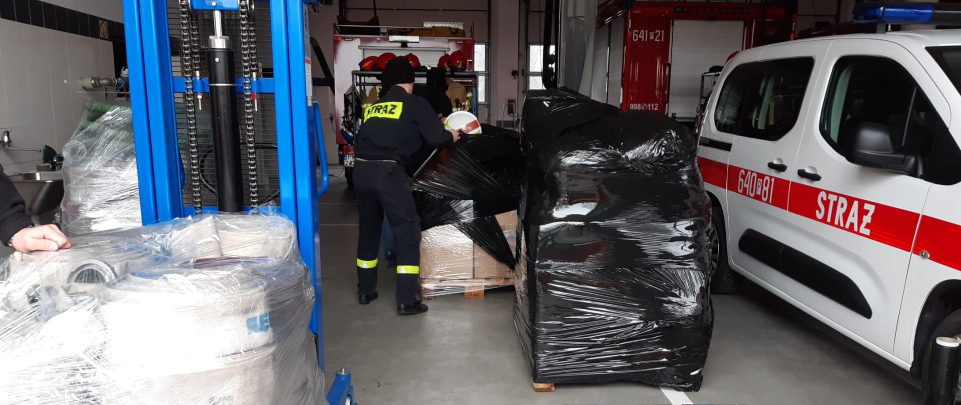 PALETY ZE SPRZĘTEM, STRAŻACY PAKUJĄ KOLEJNE