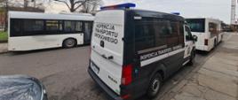 Na pierwszym planie stoi oznakowany radiowóz ITD. W tle dwa kontrolowane autobusy podmiejskie.