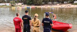 Wspólne zdjęcie służb ratowniczych na plaży przy zalewie Blewązka w Kobylej Górze.