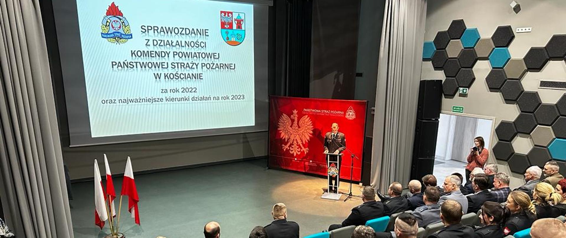 KOŚCIAŃSCY STRAŻACY PODSUMOWALI 2022 ROK. Strażacy i osoby cywilne siedzą na sali kinowej podczas narady podsumowującej rok 2022.